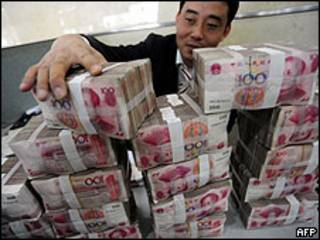 Un hombre, junto a billetes de yuan, la moneda china