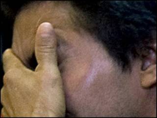 Un hombre cubriéndose el rostro / Foto de archivo