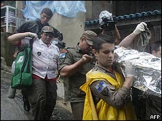 Socorristas en Rio de Janeiro llevan a una víctima de las inundaciones.