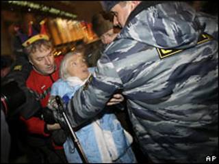 Сотрудник милиции задерживает Людмилу Алексееву