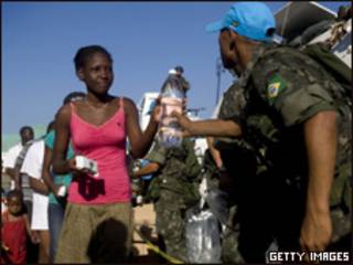 Foto divulgada pela Minustah mostra militar brasileiro entregando água para haitiana (Getty Images, 22 de janeiro)