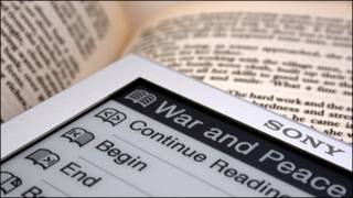 Dos libros, el de papel y el electrónico convivendo en la biblioteca