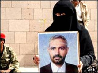 سيدة تحمل صورة الصحافي اليمني محمد المقالح