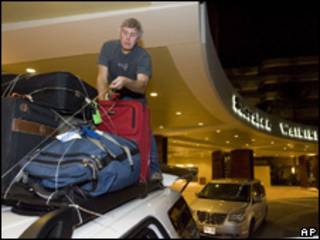 Un hombre coloca sus pertencia sobre un vehículo en un hotel de Hawaii