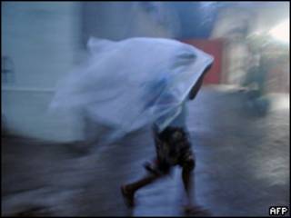 Mujer se protege de la lluvia en Haití