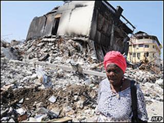 Mujer pasa frente a ruinas de un edificio en Puerto Príncipe