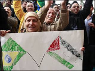 Mulher segura cartaz com bandeiras do Brasil e da Palestina durante visita de Lula a Ramallah (Foto: Ricardo Stuckert / PR)