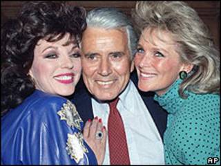 John Forsythe (centro) con las protagonistas de Dinastía Joan Collins (izquierda) y Linda Evans