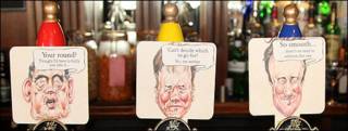 Caricaturas de candidatos en grifos de cerveza en un pub inglés