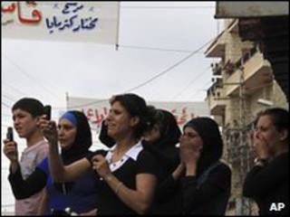 سكان محليون يشاهدون سحل جثة القتيل