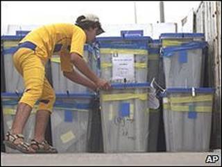 Trabajador iraquí junto a urnas electorales