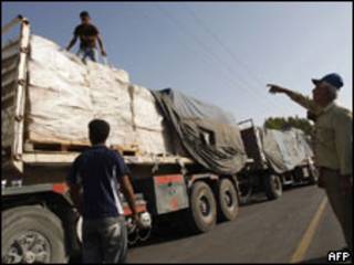 Trabalhadores palestinos inspecionam chegada de mantimentos em Rafah.