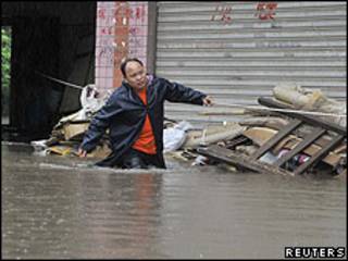 Hombre en calle inundada de Chongqing.