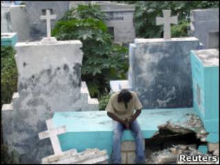Homem reza em cemitério destruído no Haiti