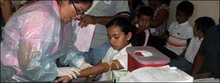 Practicando un examen de sangre en Siti del Niño.