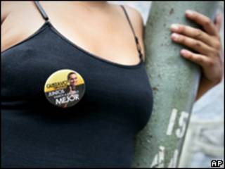 Mujer lleva un prendedor con propaganda electoral de Gustavo Rojas