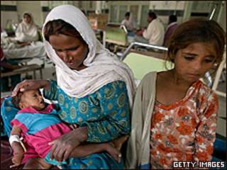 Mujer con sus hijos en hospital de Pakistán