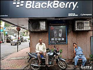 Dos hombres ante un cartel de Blackberry en India