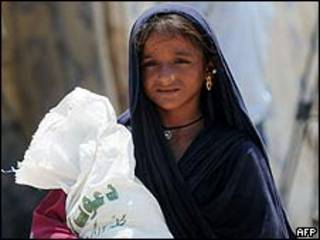 Niña desplazada llevando una bolsa con víveres