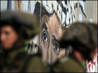 Soldados israelenses em frente a imagem de Yasser Arafat