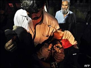Homem carrega vítima de ataque em Kohat, Paquistão (AFP/Getty)