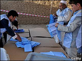 Tres hombres cuentan las papeletas de votación