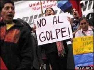 Manifestantes com cartazes em frente à embaixada equatoriana em Lima, no Peru