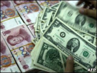 Funcionário de banco na China conta notas de dólar e iuan
