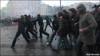 Участники беспорядков на Манежной площади 11 декабря 2010 г. сносят металлические заграждения