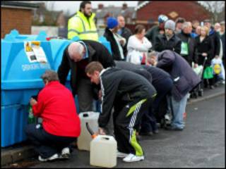 people queue to fill bottles
