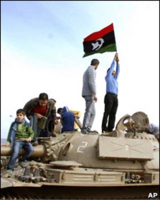 Manifestantes na cidade líbia de Benghazi seguram bandeira da época pré-Khadafi