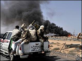 Rebeldes observam incêndio no caminho para Sirte, cidade natal de Mumar Khadafi, na Líbia (Foto: AFP/Getty)