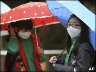 Jovens sul-coreanas se protegem de chuva