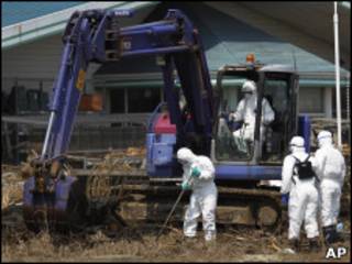 Policias usam roupas protetoras durante buscas em Fukushima (AP)