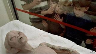 Niños observan una figura de extraterrestre mostrada en Roswell