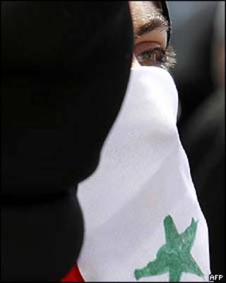 Mulher envolta em bandeira síria em manifestação contra o governo de Damasco em Amã/Afp