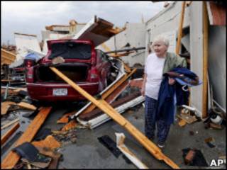 Mulher toma pertences de casa destruída pelo tornado no Alabama