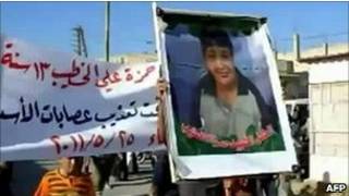 عکسی از حمزه خطیب در دست معترضان