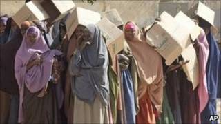 نساء صوماليات يحملن معونات غذائية