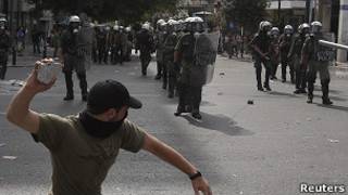 Manifestante a punto de lanzar piedra contra policías en Atenas