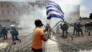 Homem carrega bandeira grega em meio a protesto em Atenas. Foto: Reuters