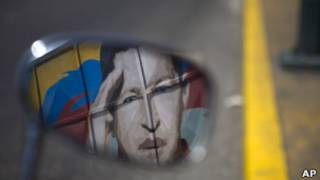 Imagem de Chávez refletida em espelho de motocicleta, em Caracas. AP