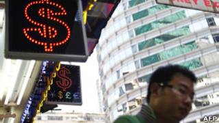Homem em frente à loja de câmbio em Hong Kong