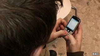 Menino usando telefone celular (BBC)