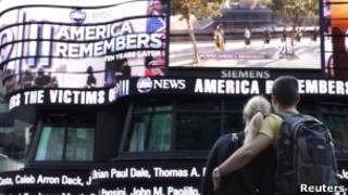 Passantes assistem à cerimônia de 11-9 no telão da Times Square (Reuters)