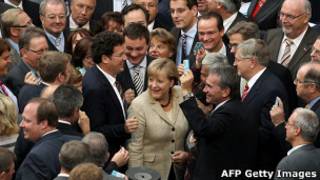 A chanceler alemã, Angela Merkel, visita o Parlamento europeu pouco antes de votação de medida que amplia poderes de fundo de resgate europeu