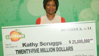Kathy Scruggs posa com réplica gigante de cheque da loteria da Geórgia