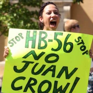 Mulher protesta contra lei de imigração do Alabama.
