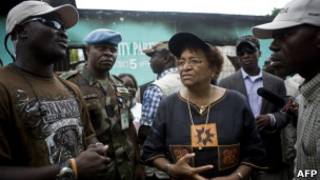 Presidente Sirleaf (centro) conversa com partidários neste sábado (AFP)