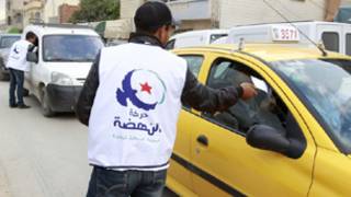 ناشط في حركة النهضة يوزع ملصقات انتخابية